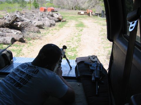 1996 Ford Bronco - Man aims a rifle from the interior of a vehicle at a shooting range.