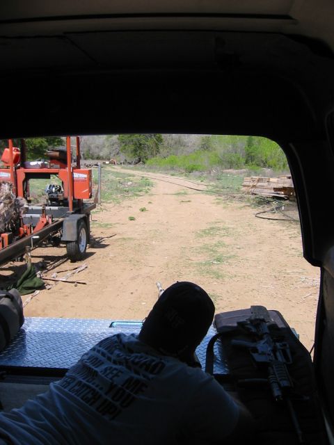 1996 Ford Bronco - Looking out from a vehicle at a person with a rifle and a sawmill in the distance.