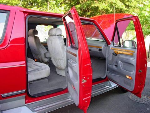 1994 Ford C-150 (Centurion Conversions) - Interior view of a red 1994 Ford C-150 (Centurion Conversions) van with all doors open.