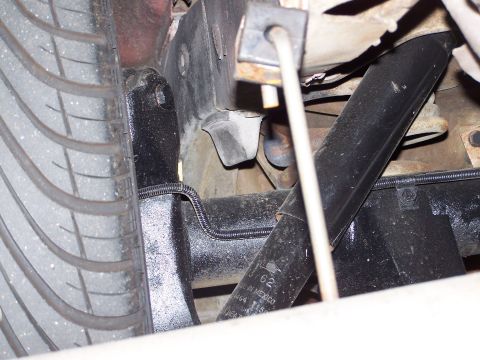 1973 Ford Ranchero - Tight underhood/wheel-well shot showing a black shock absorber body marked MADE IN MEXICO mounted alongside a freshly black-painted lower c…
