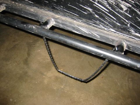1995 Ford Bronco - A chain is attached to a pipe on the vehicle's frame.