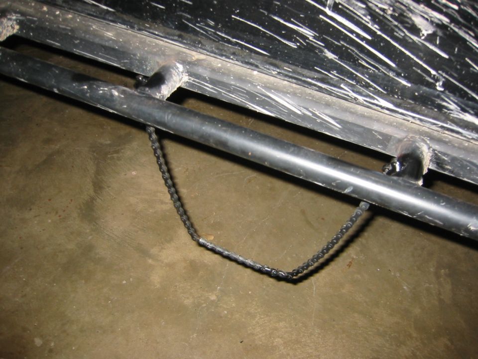 close-up of black metal frame with a chain attached to a pipe