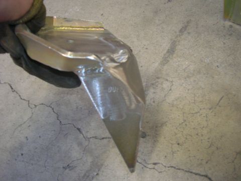 1996 Ford Bronco - A metal part, possibly a suspension component, is held up for inspection.