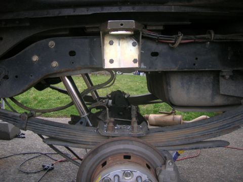 1996 Ford Bronco - Close-up view of a vehicle's rear suspension system, showing leaf springs and shock absorbers.