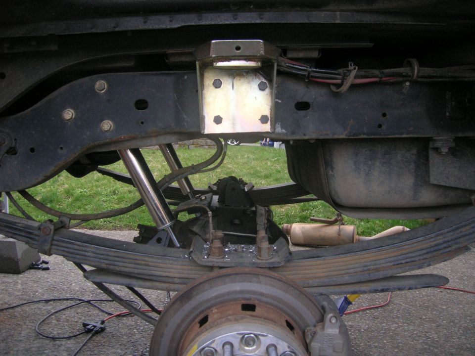 Rear suspension with leaf springs, shocks, and fuel tank. Modified bracketry is visible