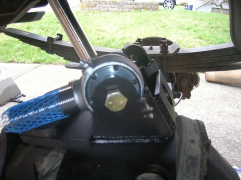 1996 Ford Bronco - This image shows a close-up view of a vehicle's rear suspension component, a prominent bolt and protective blue mesh.