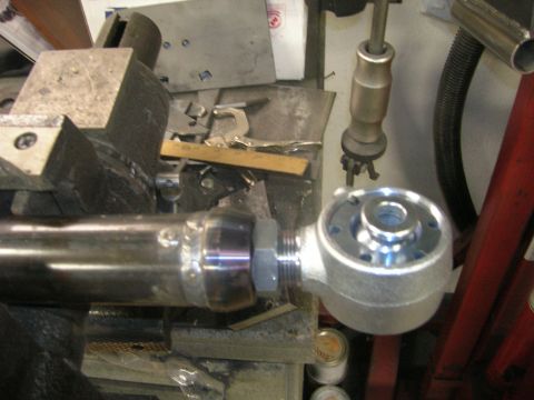 1996 Ford Bronco - A metal suspension part is secured in a vise, likely for repair or modification.