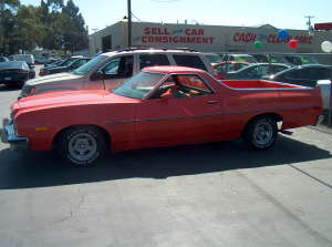 1973 Ford Ranchero - Small, low-resolution side profile of a red-orange Ford Ranchero coupe-utility sitting on a paved consignment lot, with SELL CAR CONSIGNMEN…