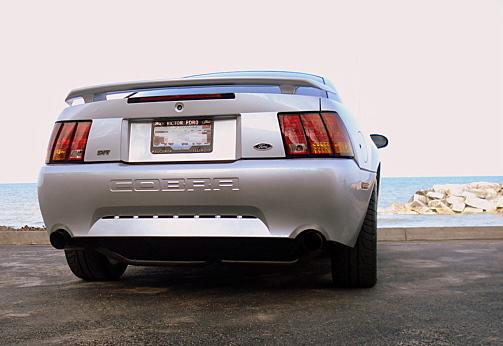 Silver Ford Mustang Cobra rear view with COBRA lettering on the trunk lid and dual exhaust tips