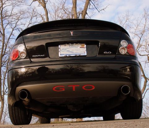 1998 Ford Taurus - Rear view of a black 2004 Pontiac GTO, prominent red GTO badging and dual exhaust pipes.