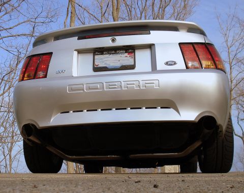 1998 Ford Taurus - Rear view of a silver Ford Mustang Cobra SVT, showing its distinctive taillights and exhaust system.