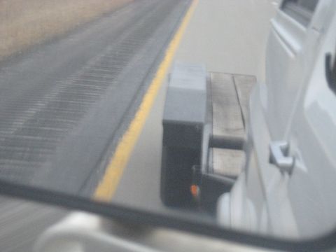 1978 Ford Bronco - White vehicle and flatbed trailer seen from the side on a highway.