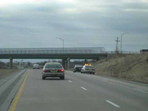 1978 Ford Bronco - Two state patrol vehicles are visible on the highway, one with its lights activated.