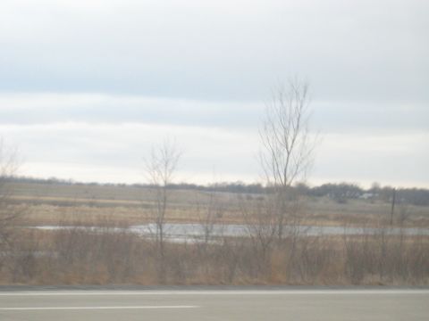 1978 Ford Bronco - A view of a rural landscape under a cloudy sky, with a body of water visible in the distance.