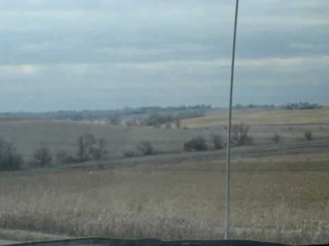 1978 Ford Bronco - A view of a desolate rural landscape from inside a vehicle on a cloudy day.