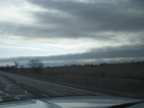 1978 Ford Bronco - View from inside a vehicle looking out at a highway under a cloudy sky.