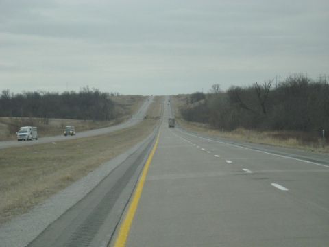 1978 Ford Bronco - Vehicles travel along a long, straight highway under an overcast sky.
