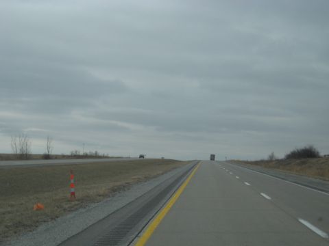 1978 Ford Bronco - A highway stretches towards the horizon under an overcast sky, with a truck and a car visible in the distance.