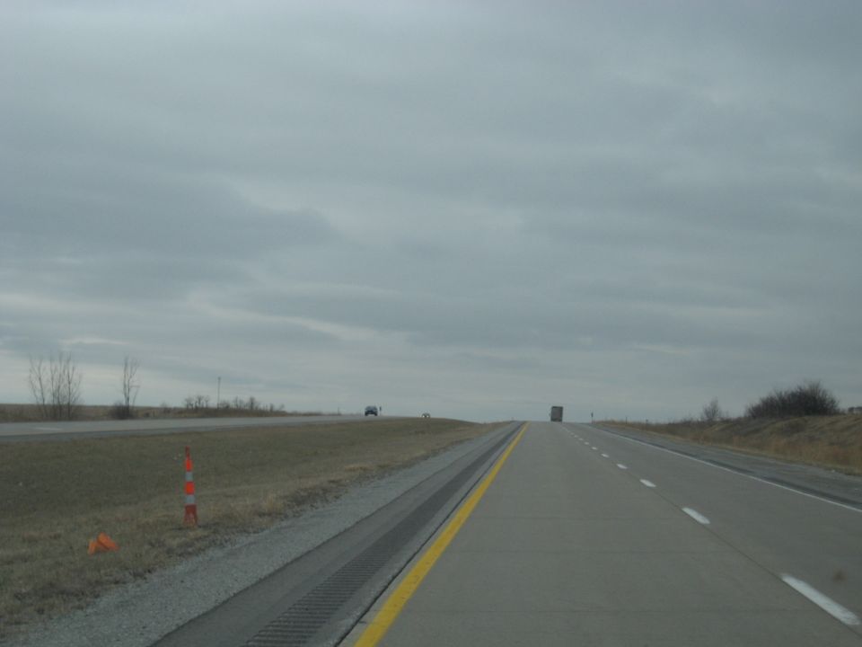 Highway scene with a distant truck and car under a cloudy sky