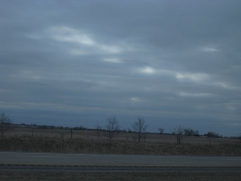 1978 Ford Bronco - A cloudy sky looms over a rural landscape with a highway visible.
