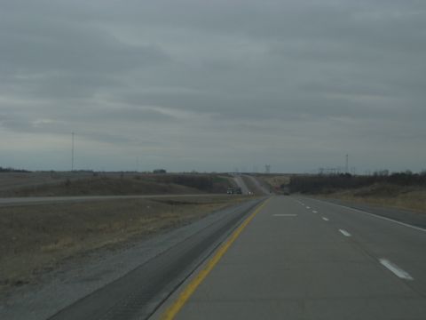 1978 Ford Bronco - Driving on a highway under a cloudy sky with sparse vegetation and distant vehicles.