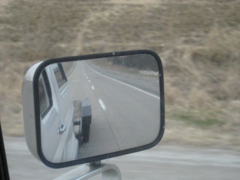 1978 Ford Bronco - Reflection in the side mirror reveals a trailer hitch attached to the vehicle.