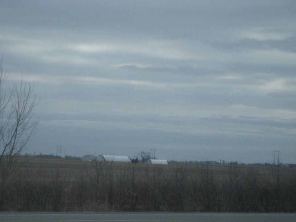 Overcast sky above a rural landscape with quonset huts