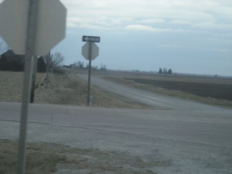 1978 Ford Bronco - A rural intersection is marked with stop and one-way signs under a cloudy sky.