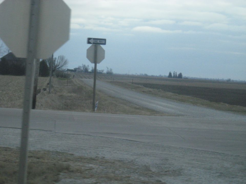 Stop sign and one way sign at a rural road intersection