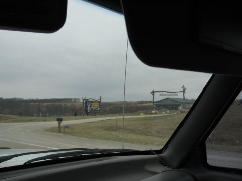 1978 Ford Bronco - A view of roadside attractions including a building and a billboard on an overcast day.