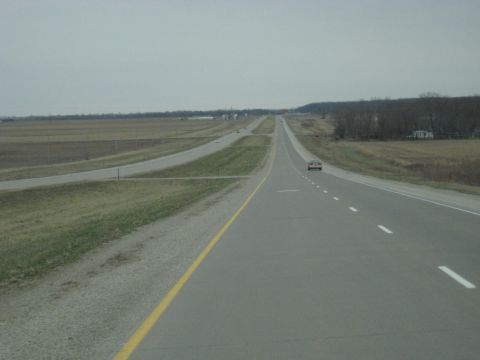 1978 Ford Bronco - A highway scene with two cars driving on a cloudy day.