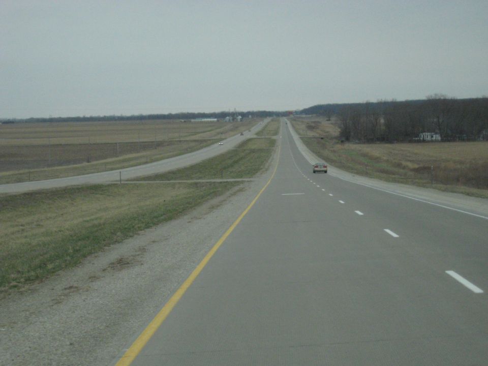 Highway stretching into the distance with two cars visible