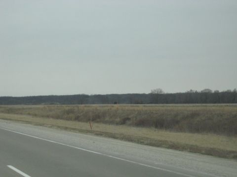 1978 Ford Bronco - A view of a rural landscape under an overcast sky, a road and fields.
