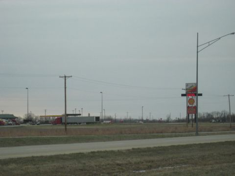 1978 Ford Bronco - A wide view of a truck stop with a Shell gas station sign and a semi-trailer truck parked.