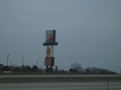 1978 Ford Bronco - Signs for Flying J Travel Plaza and Shell station are visible from the road on an overcast day.