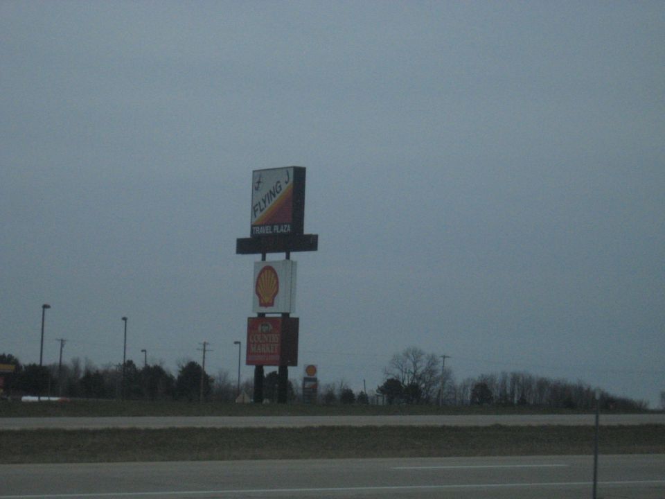 Flying J Travel Plaza and Shell station signs seen from a highway