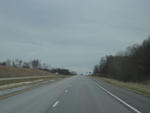 1978 Ford Bronco - Driving on a highway with bare trees lining the sides and two vehicles ahead.