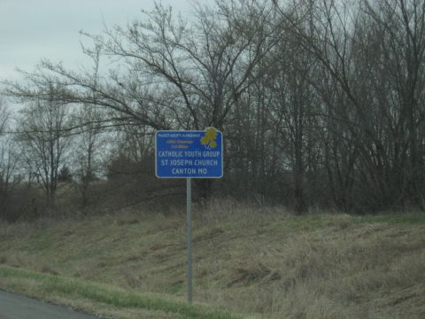 1978 Ford Bronco - A blue roadside sign indicates directions to St. Joseph Church and its Catholic Youth Group in Canton, MO.