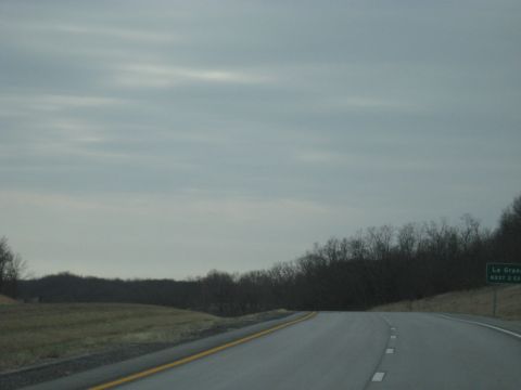 1978 Ford Bronco - A green road sign indicates an upcoming exit on a highway under a cloudy sky.