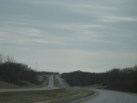 1978 Ford Bronco - A highway winds through a rural landscape under an overcast sky, with a few vehicles visible in the distance.