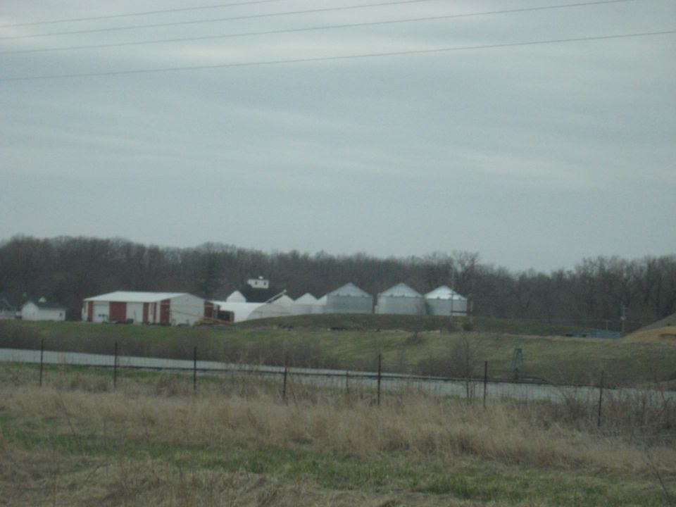 Farm with silos and buildings under a cloudy sky