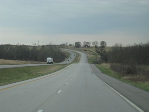 1978 Ford Bronco - A white semi-truck travels down a highway on an overcast day, with a few other cars visible in the distance.