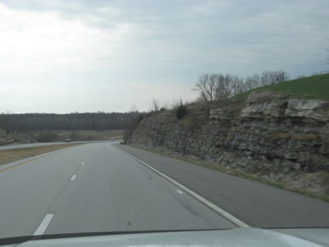 1978 Ford Bronco - Driving on a highway with rocky terrain and trees alongside the road.