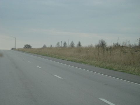 1978 Ford Bronco - A view of a highway roadside with dry grass and utility poles on an overcast day.