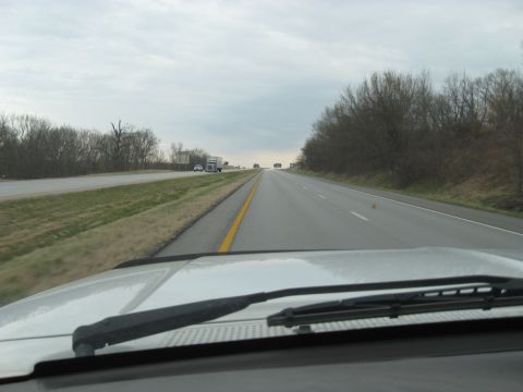 1978 Ford Bronco - View from the driver's seat on a cloudy day, looking down a multi-lane highway with other cars and trucks ahead.