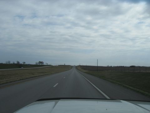 1978 Ford Bronco - Driving down a long, empty highway under a cloudy sky.