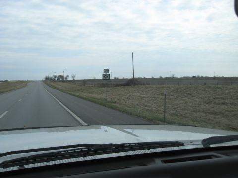 1978 Ford Bronco - View from inside a vehicle driving on a highway through a rural landscape under a cloudy sky.