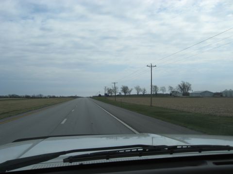 1978 Ford Bronco - Driving down a rural highway with overcast skies and farmland on either side.