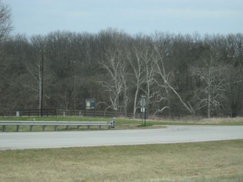 1978 Ford Bronco - A view of a rural roadside with a guardrail and a sign indicating a turn.