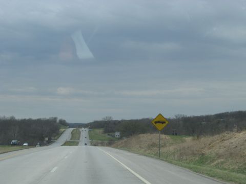 1978 Ford Bronco - A highway scene with a sign indicating trucks crossing ahead and a speed limit of 55.